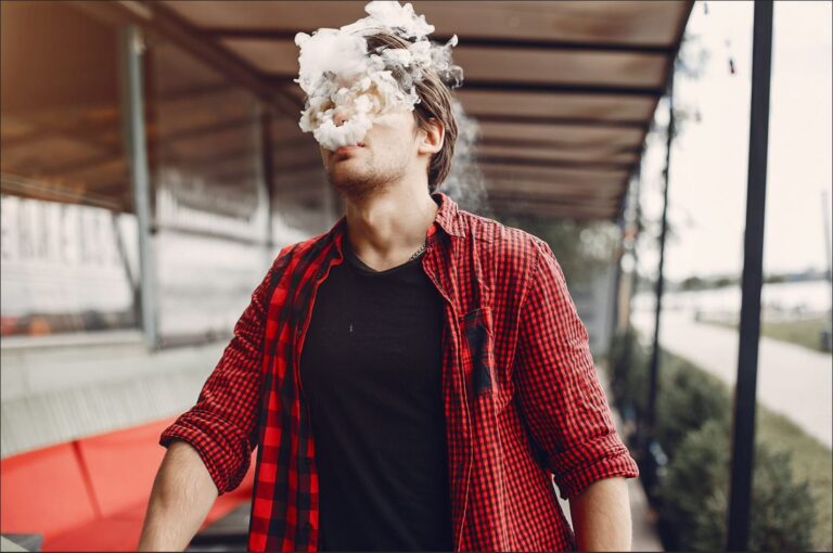 Man smoking an e-cigarette, reflecting concerns about whether vaping can cause erectile dysfunction.