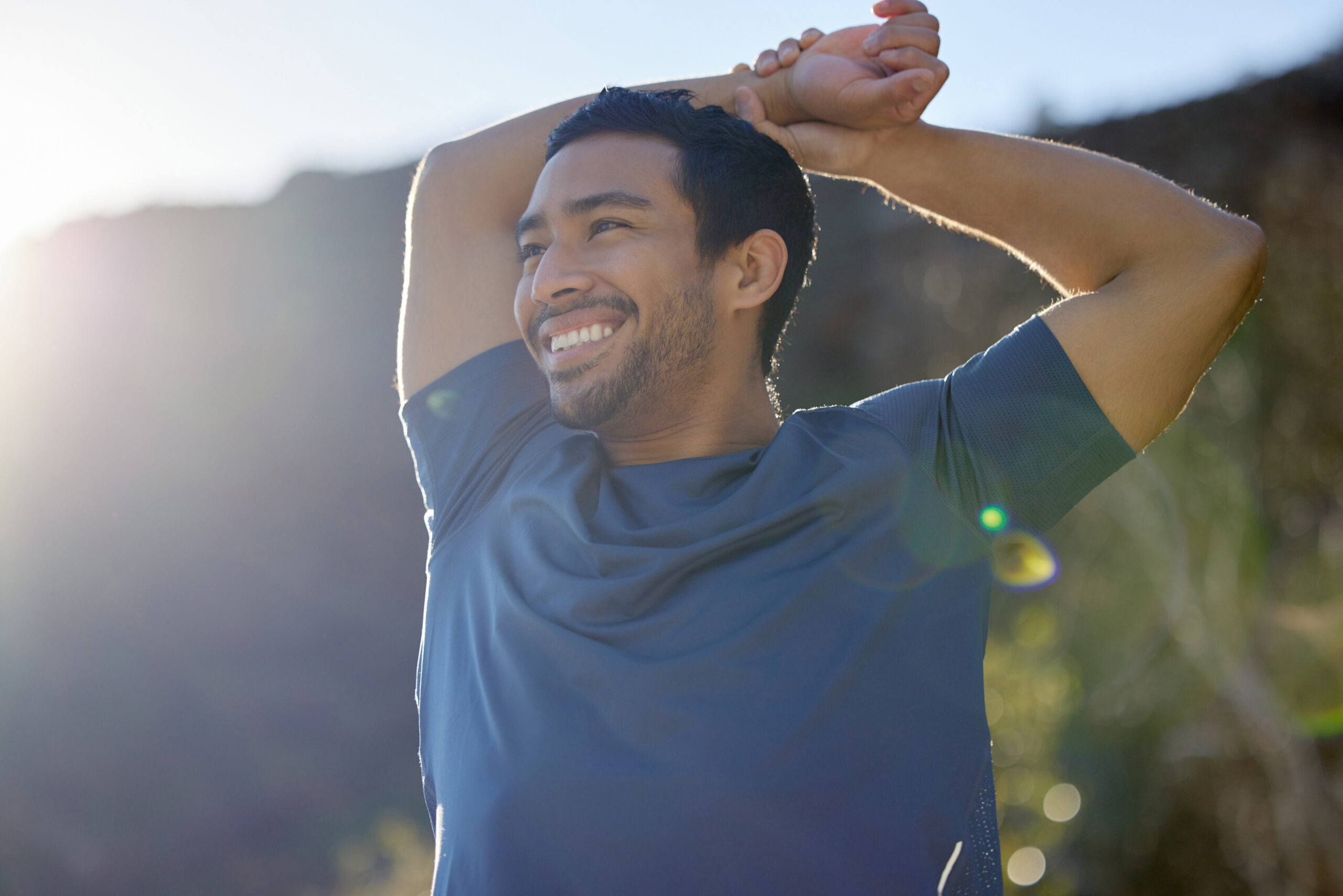 Fit man outside pausing a run to stretch and catch his breath as he's working on his weight loss journey along with peptides.